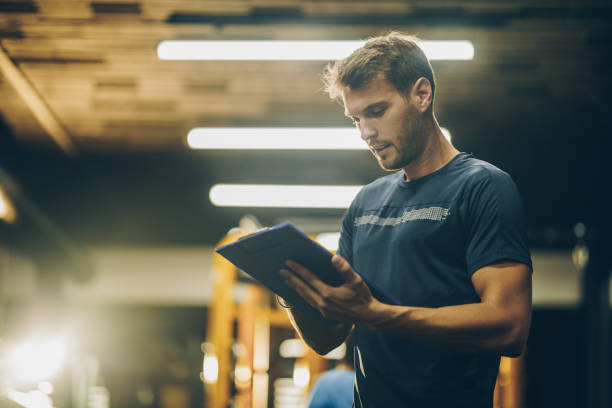 Strength coach providing guidance during a gym workout.